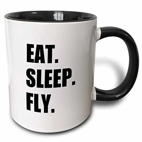 A classic black ceramic mug with the white text 'Eat Sleep Fly' printed on it.