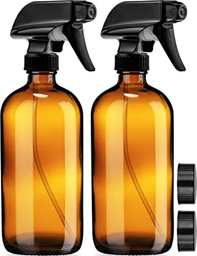 Two amber glass spray bottles with protective caps and adjustable nozzles