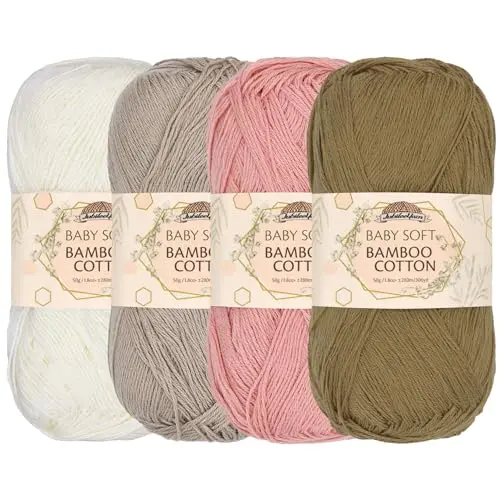 Four skeins of JubileeYarn Baby Soft Bamboo Cotton in neutral tones of brown, cream, and pink.