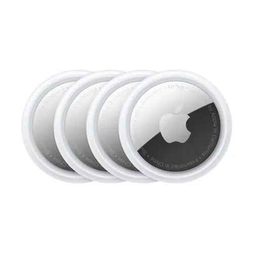 Four Apple AirTags next to a passport and suitcase.