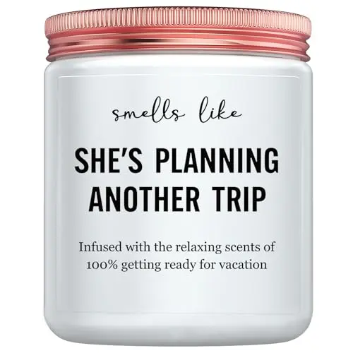 Glass jar candle with a label featuring travel-themed artwork and text
